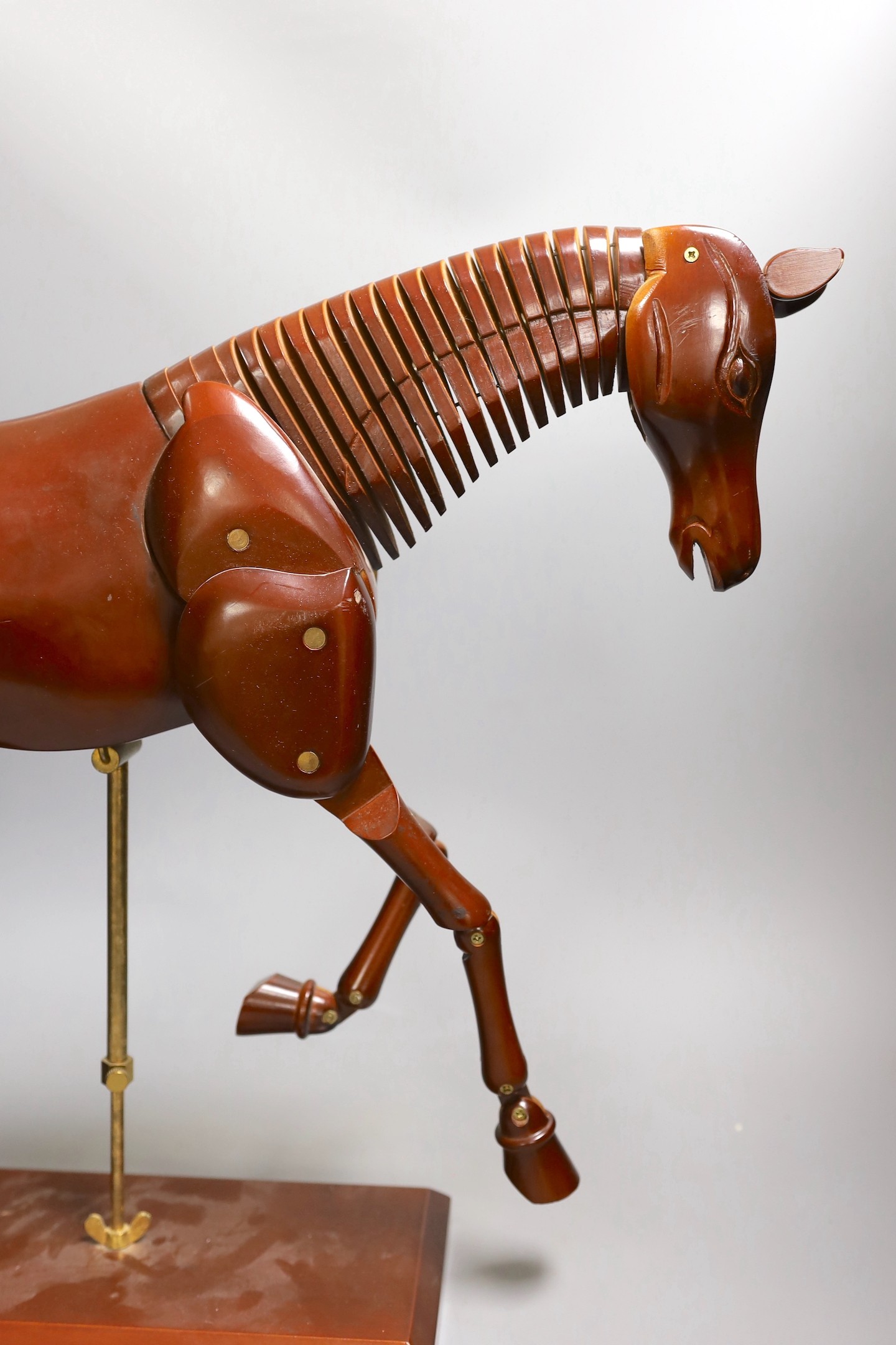 A modern artist's wooden articulated model of a horse, on stand, approx 51 cms wide x 46cms high